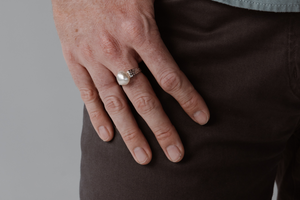 A man wears his statement pearl ring that features a thick gold band and Australian keshi pearl from our Cygnet Bay Pearl Farm.