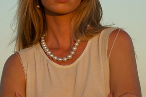 A woman gazes into the Kimberley sunset while wearing her Cygnet Bay grown Australian South Sea pearl strand necklace.