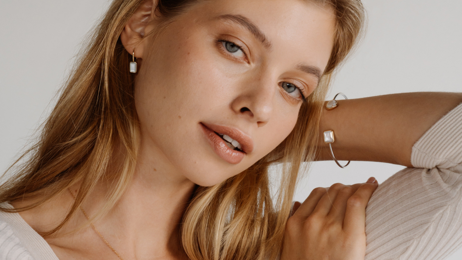 A woman wears her stunning Radiance mother of pearl jewellery collection, which features emerald cut pieces of Mother of Pearl shell grown at our Cygnet Bay Pearl Farm.