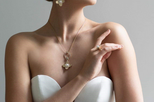 A bride wears her Star of the West set, which is a pair of pearl earrings, pearl pendant and pearl ring all designed with a nod to the art deco era.