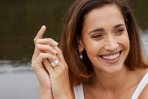 A woman smiles as she wears her beautiful set of Stella collection pieces, all Australian South Sea pearls set alongside white diamonds.