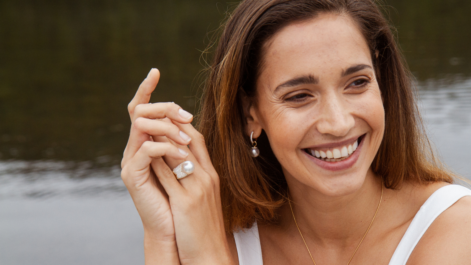 A woman smiles as she wears her beautiful set of Stella collection pieces, all Australian South Sea pearls set alongside white diamonds.