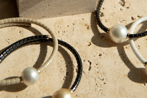 A collection of pearl jewellery pieces part of the Terra Range, featuring ceramic links and set in 18ct yellow gold.