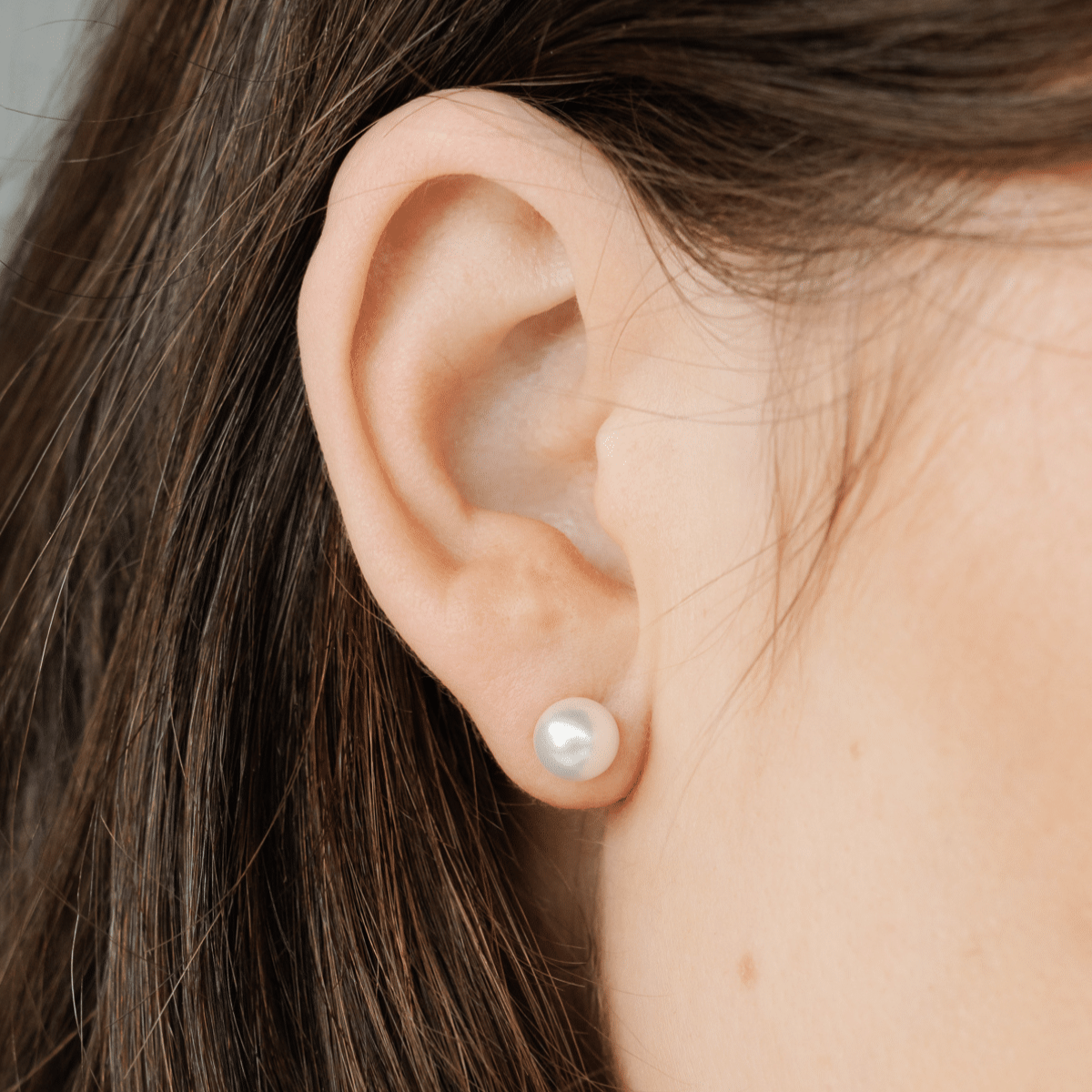A woman wears her beautiful Australian Akoya pearl studs.