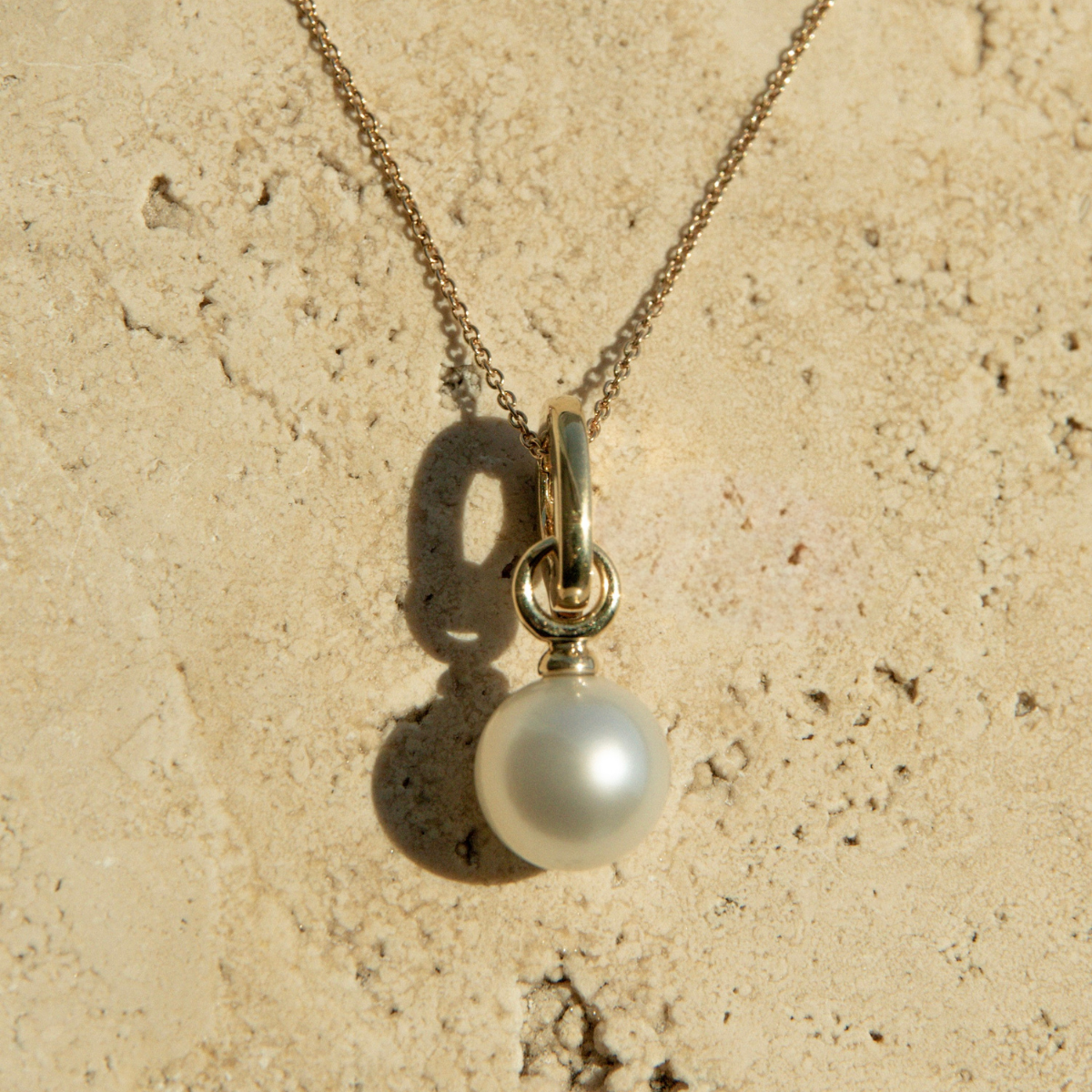 Pearl necklace on a textured beige surface