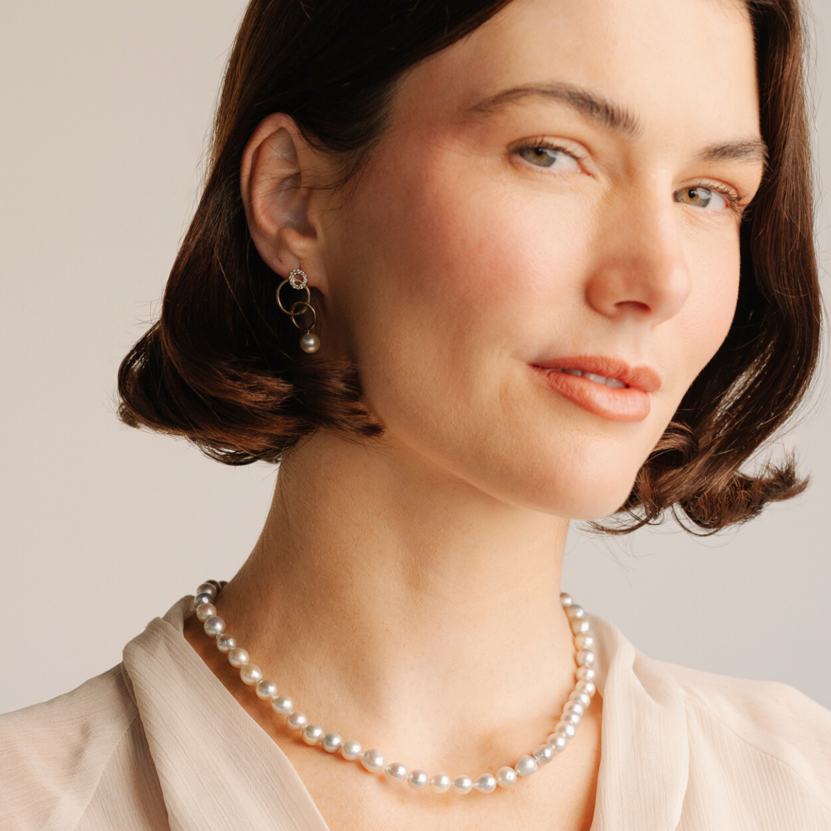 These playful earrings feature a pair of Broken Bay (NSW) grown 6.5mm AA grade Australian Akoya pearls , gracefully suspended from an intricate trio of gold loops.