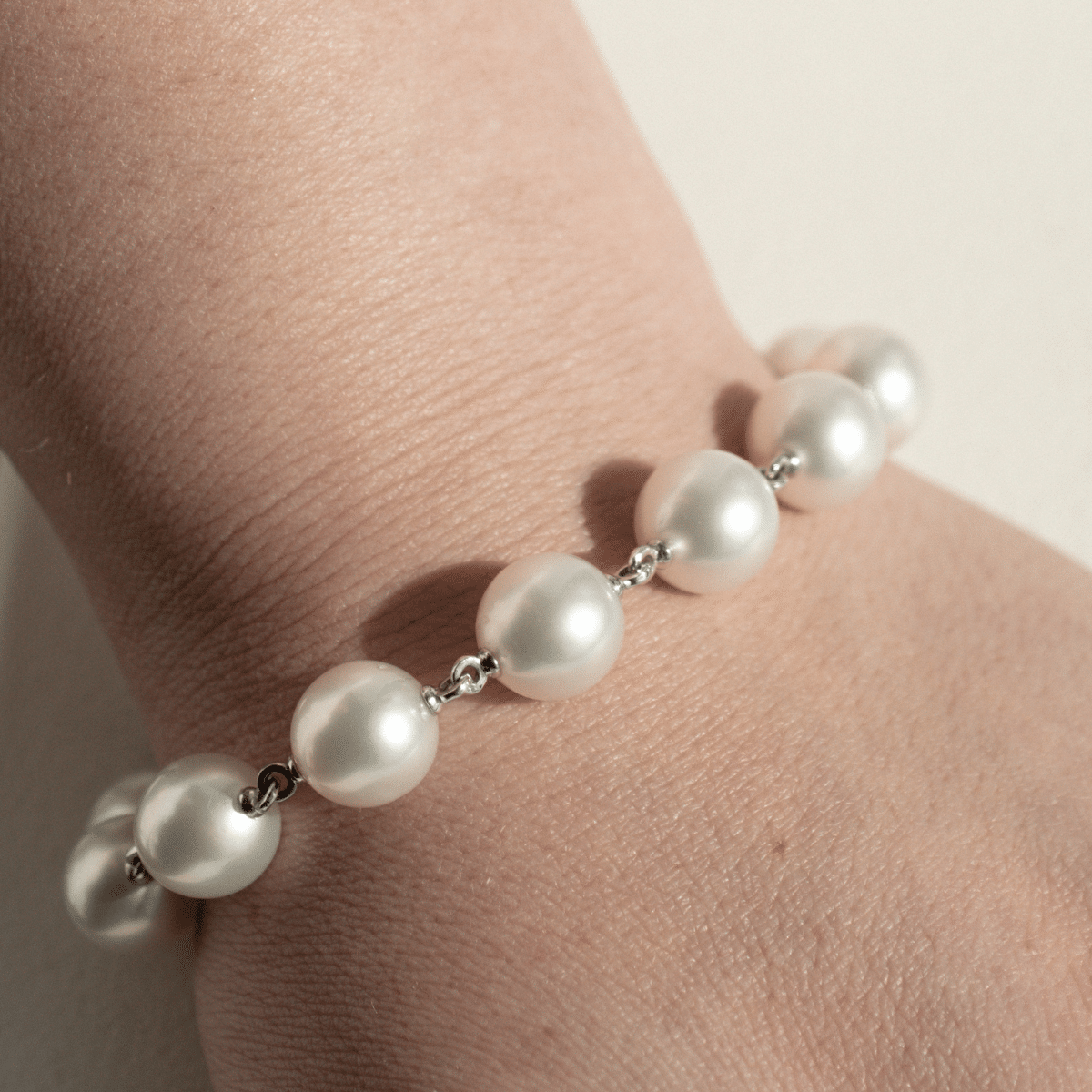 A woman wears her stunning Cocos Pearl Strand Bracelet, with pearls shining with their natural white colour and lustre.