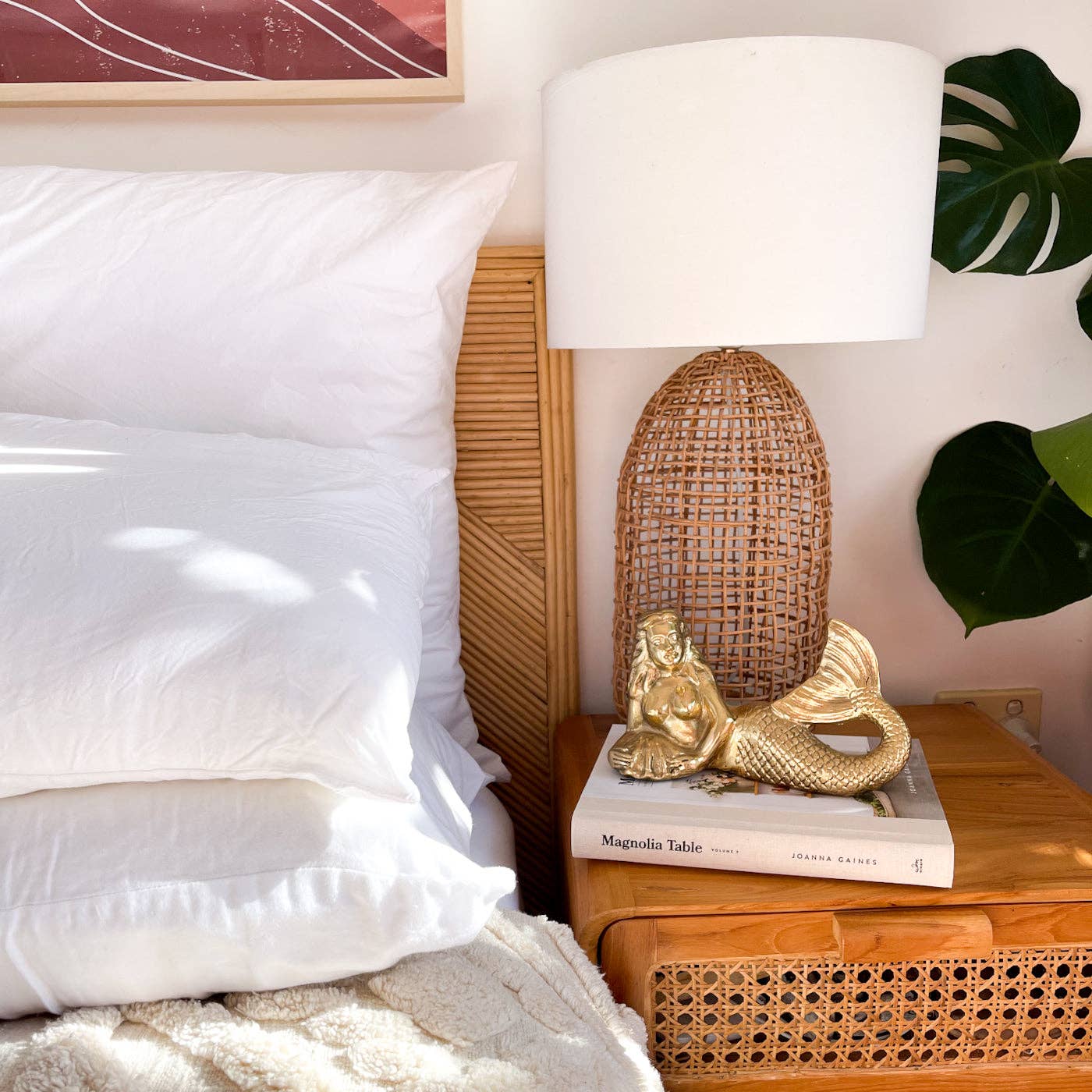 Decorative mermaid figure on a book with a lamp and pillows in the background
