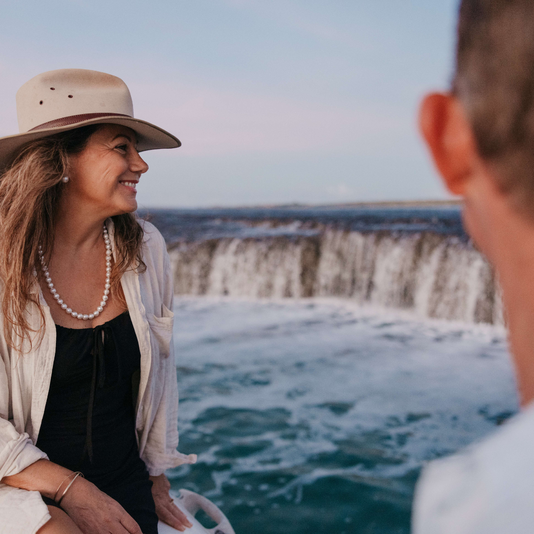 A guest smiles broadly as the looks at our Waterfall Reef during a Sea Safari tour. She wears her stunning Pearls of Australia pearl strand necklace and matching pearl stud earrings.