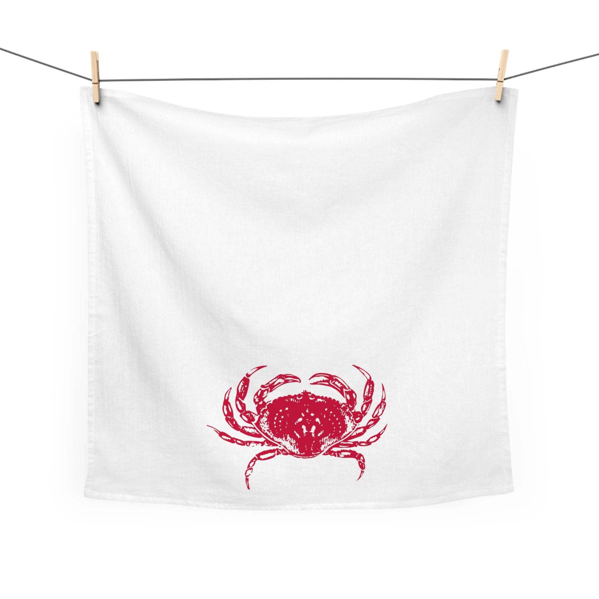 White towel with red crab design hanging on a clothesline
