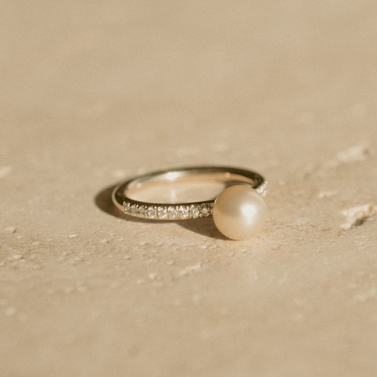 A stunning Eternal Diamond Pearl Ring featuring our Broken Bay grown Australian Akoya pearl set alongside a row of white glimmering diamonds on a gold band.