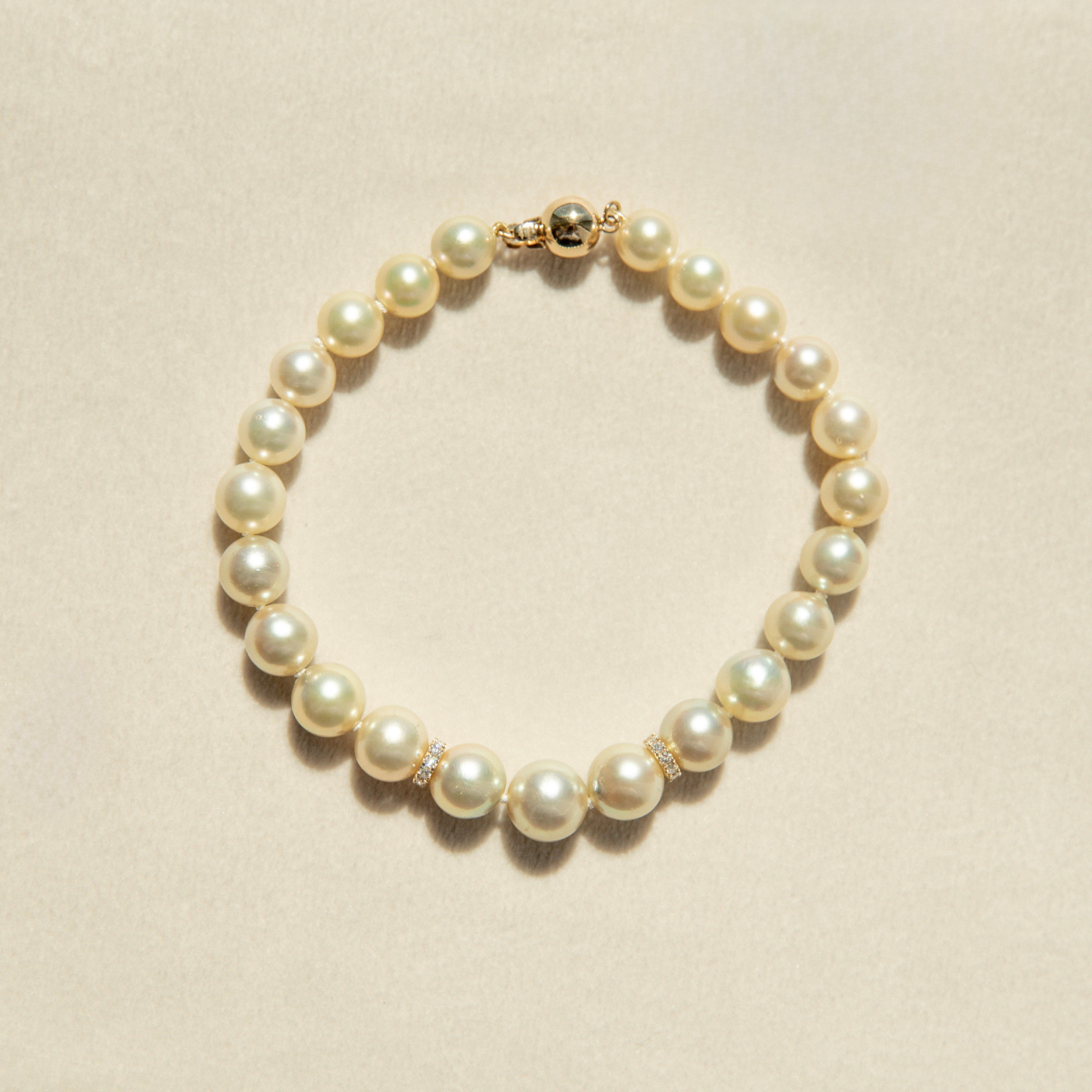 Pearl strand bracelet on a beige background