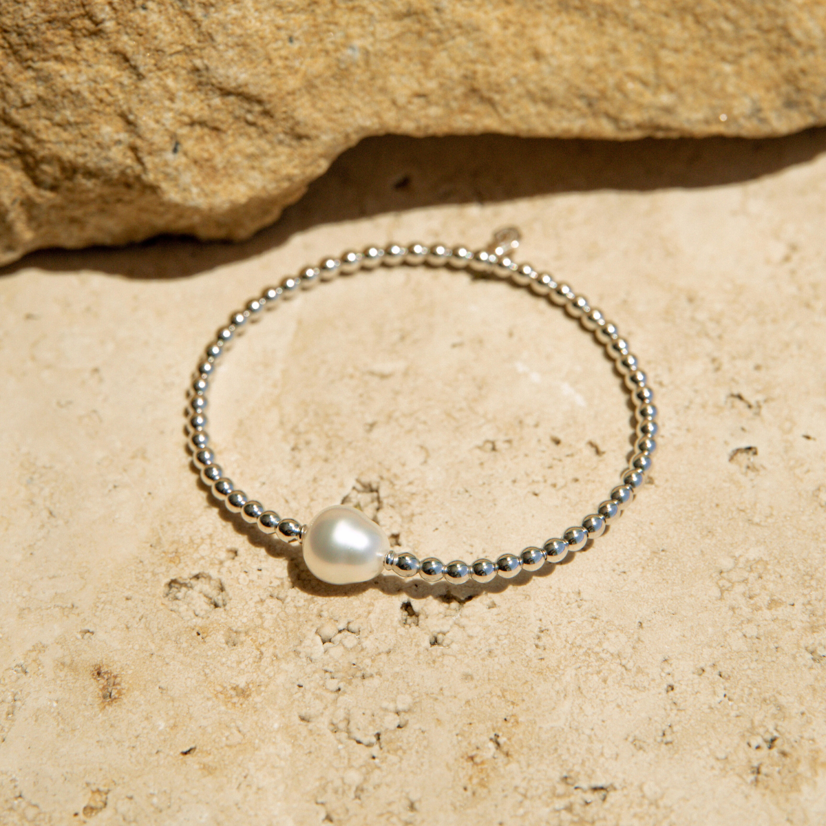Bracelet with a pearl on a stone surface