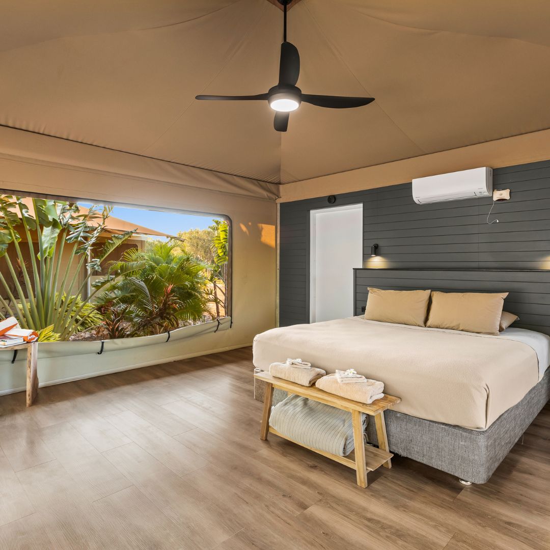 Photo of our comfortable Safari Tent that includes a large King bed, air-conditioning, a ceiling fan, and all the amenities needed.