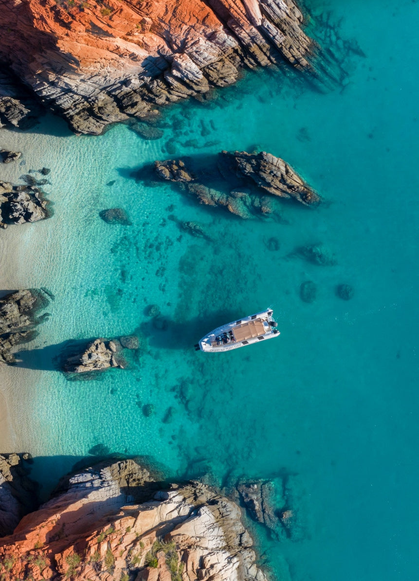 A tour boat sitting in the sitting in the still, tranquil waters of Cygnet Bay during an Island Explorer tour.