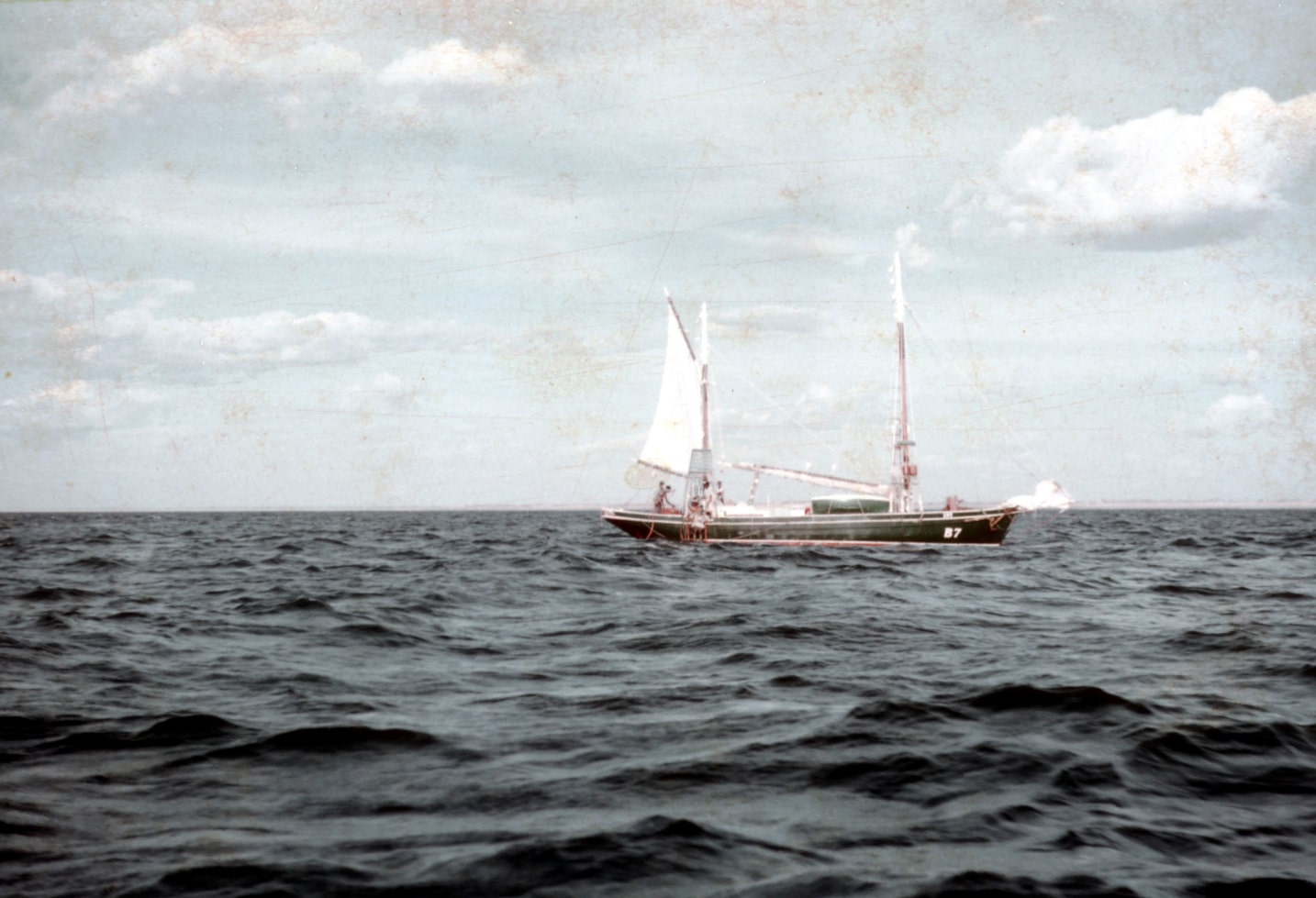 A historical photo of a pearling vessel with divers looking for wild mother of pearl shell.