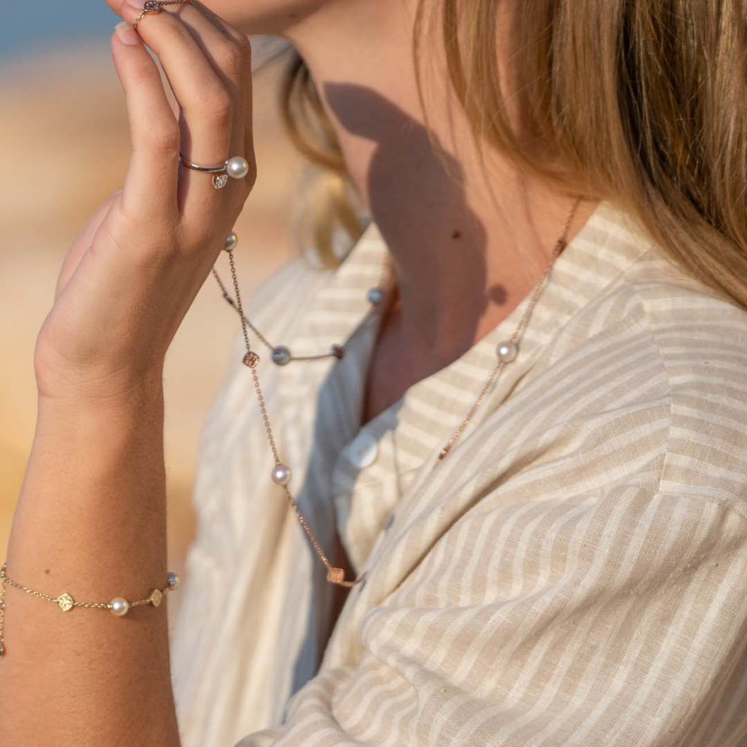 A woman wears her elegant Seagrass Pearl Necklace featuring Broken Bay (NSW) grown Australian Akoya pearls set on a gold chain.