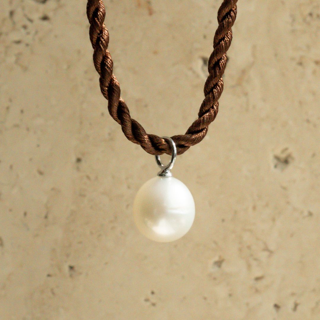 A stunning Cygnet Bay grown Australian South Sea pendant set in sterling silver or gold hanging from a silk cord rope.