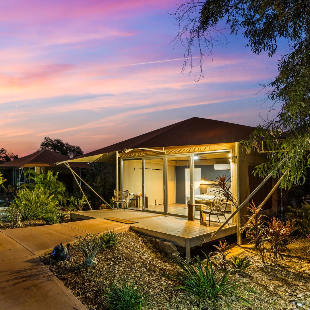 A photo of our Safari Tent at dusk, with a beautiful pastel sunset in the background.