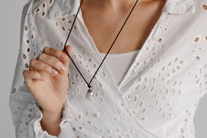 A woman wears her stunning Stella Black Diamond Pearl Pendant on a 100% Silk Cord Rope.