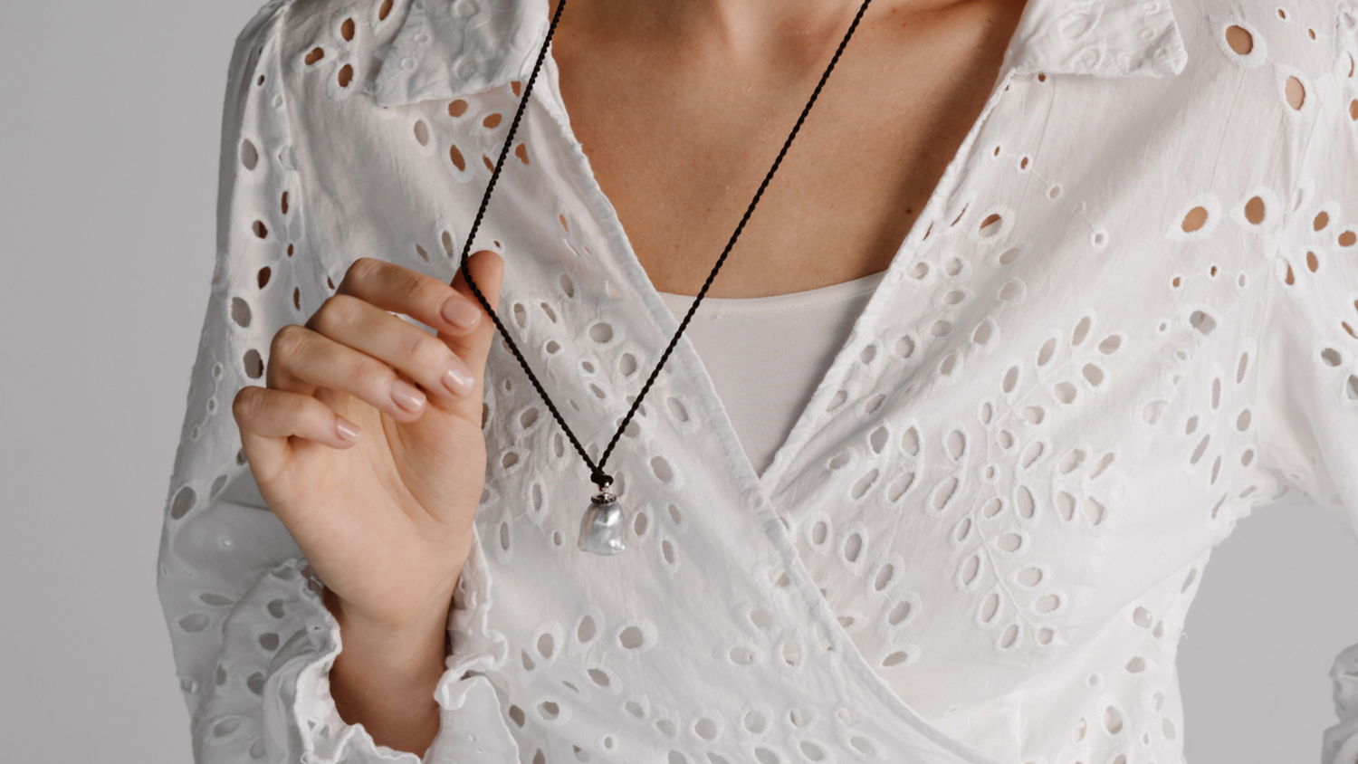 A woman wears her stunning Stella Black Diamond Pearl Pendant on a 100% Silk Cord Rope.