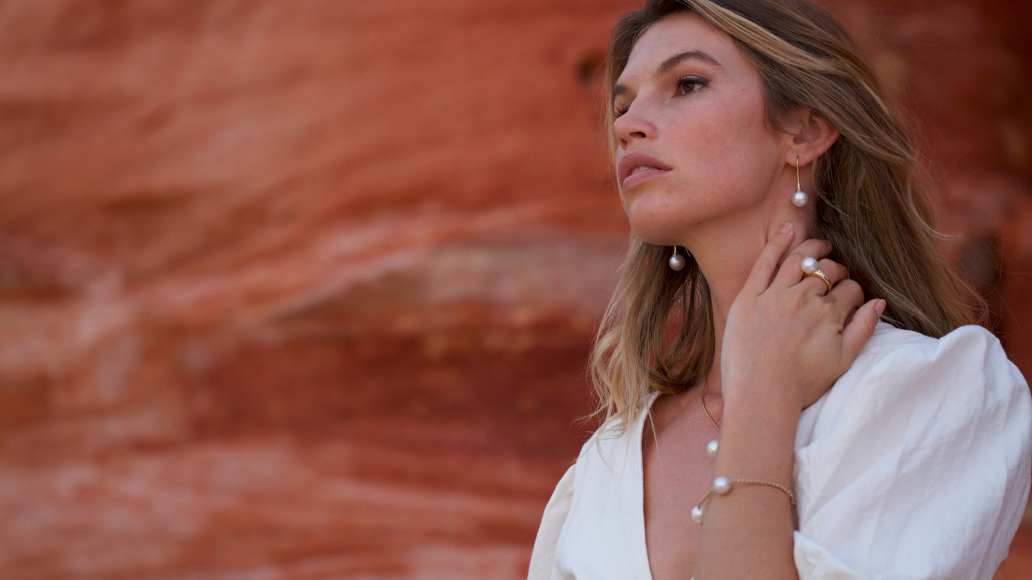 A woman wears her stunning Pearls of Australia pearl jewellery pieces, set in gold.