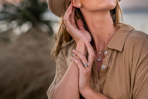 A woman watches the sunrise at Cygnet Bay Pearl Farm, while wearing her Kimberley Lily Keshi pearl jewellery collection set in various golds.