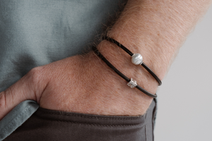 A man wears his pearl bracelets stacked on top of each other as a great statement.