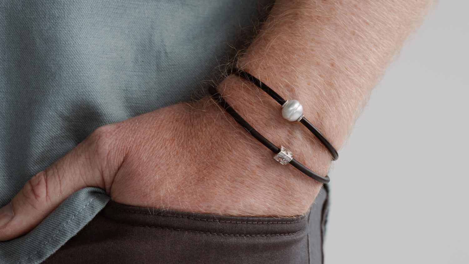 A man wears his pearl bracelets stacked on top of each other as a great statement.