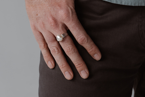 A man wears his statement pearl ring that features a thick gold band and Australian keshi pearl from our Cygnet Bay Pearl Farm. 