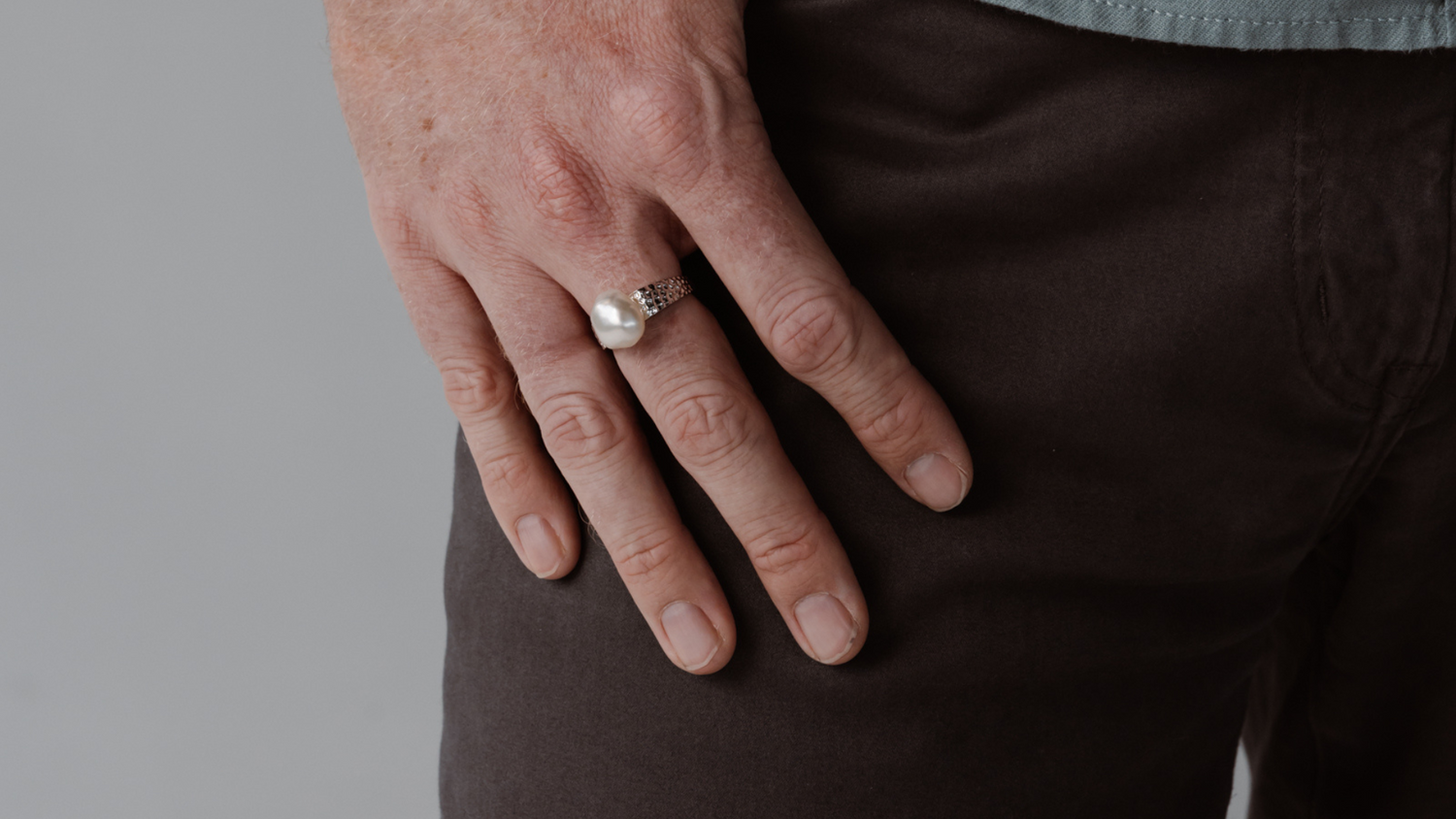 A man wears his statement pearl ring that features a thick gold band and Australian keshi pearl from our Cygnet Bay Pearl Farm.