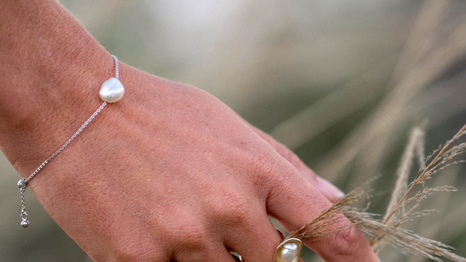 A woman wears her stunning chain bracelet that features an Australian Keshi pearl set on a delicate solid gold chain.