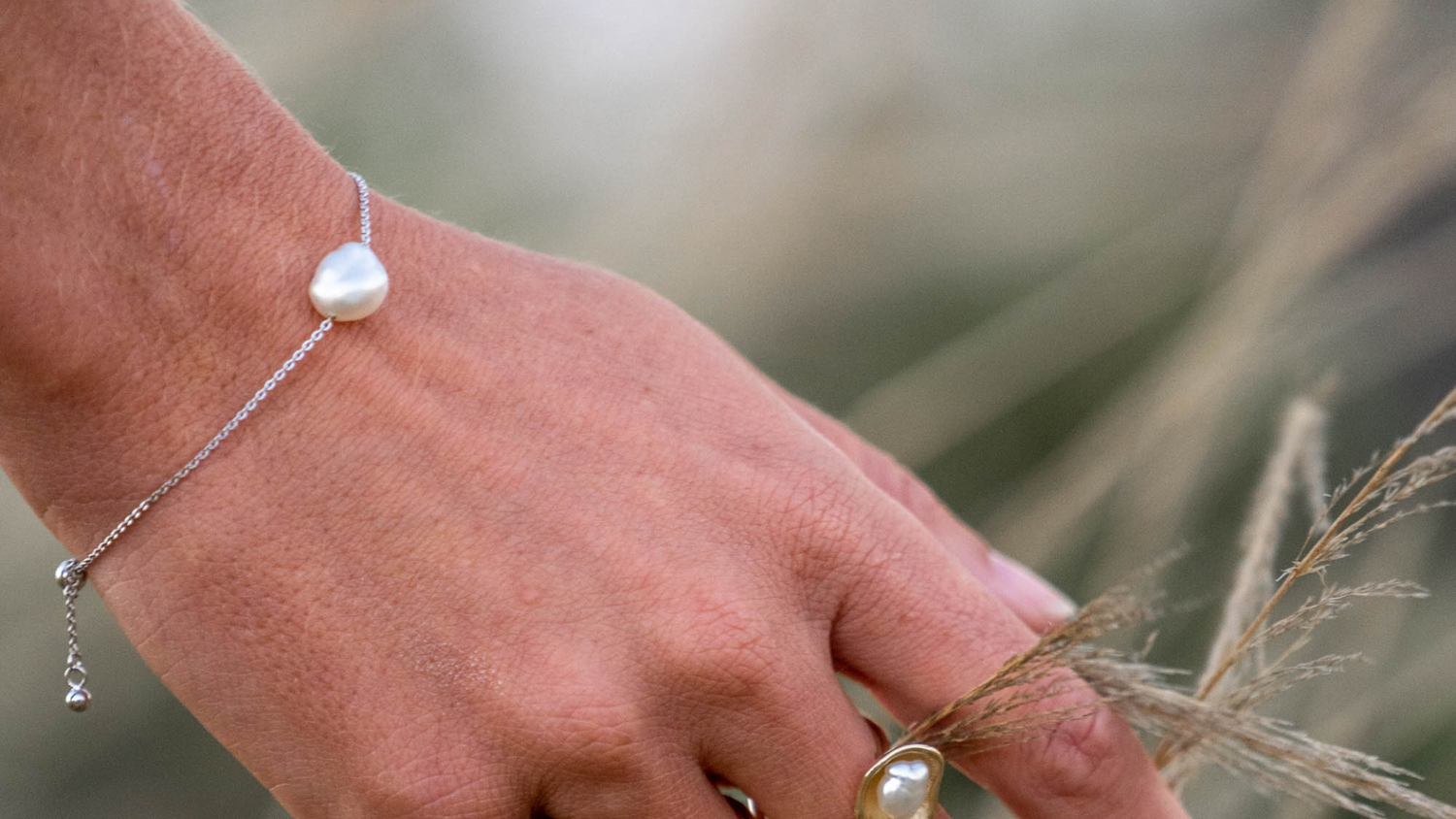 A woman wears her stunning chain bracelet that features an Australian Keshi pearl set on a delicate solid gold chain. 