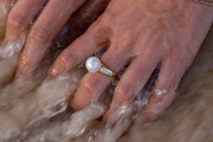 A person wears their stunning Pearl Diamond Ring, shining with natural colour and lustre.