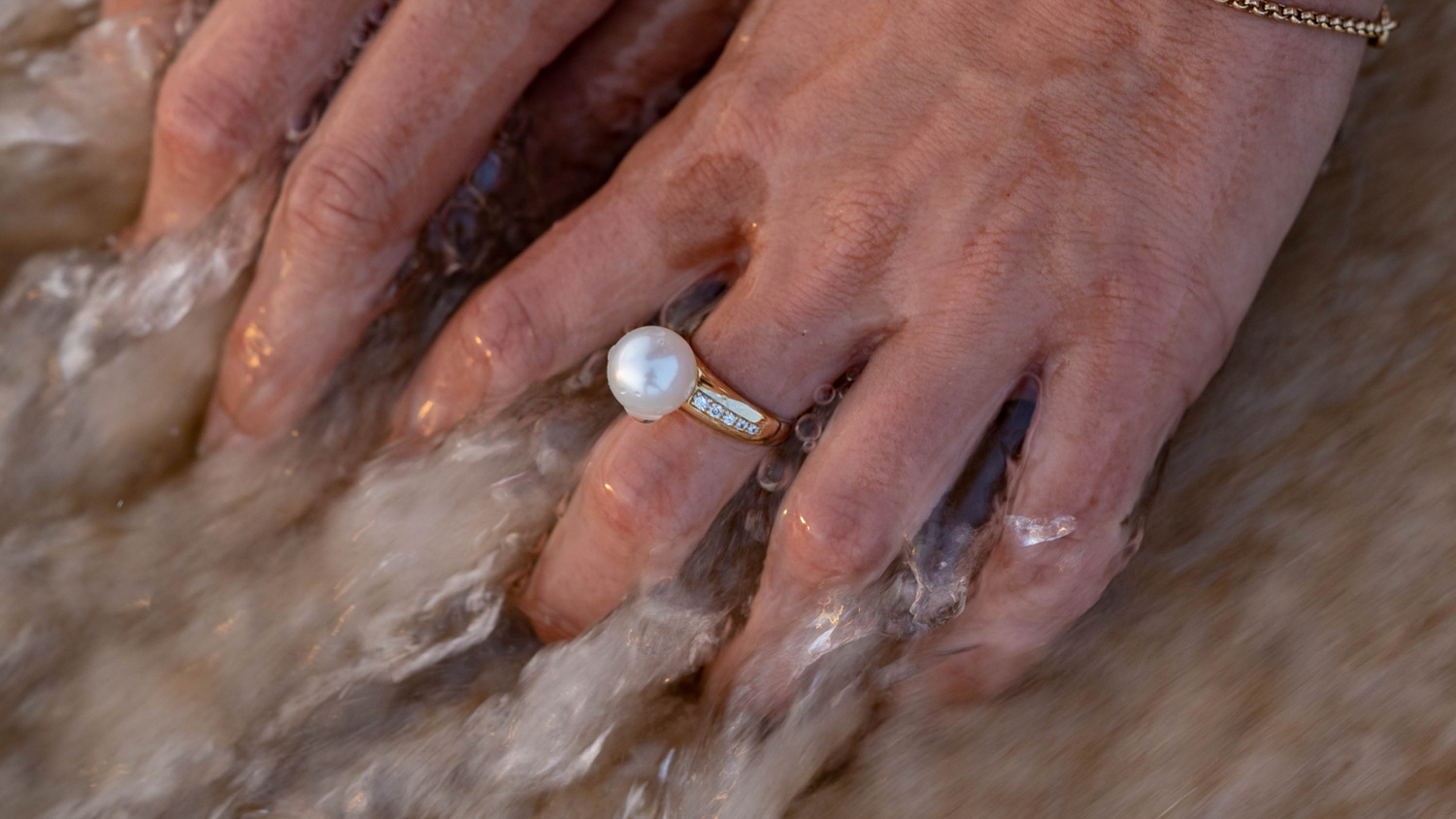 A person wears their stunning Pearl Diamond Ring, shining with natural colour and lustre.