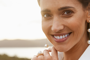 A woman wears her gorgeous Provenance Drop Earrings, that feature both our Australian South Sea pearls and Akoya pearls set on a delicate gold chain.