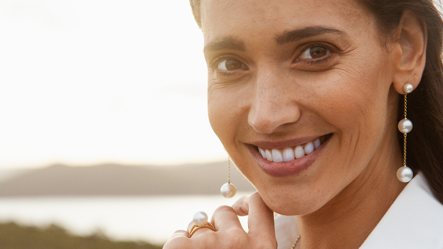 A woman wears her gorgeous Provenance Drop Earrings, that feature both our Australian South Sea pearls and Akoya pearls set on a delicate gold chain.