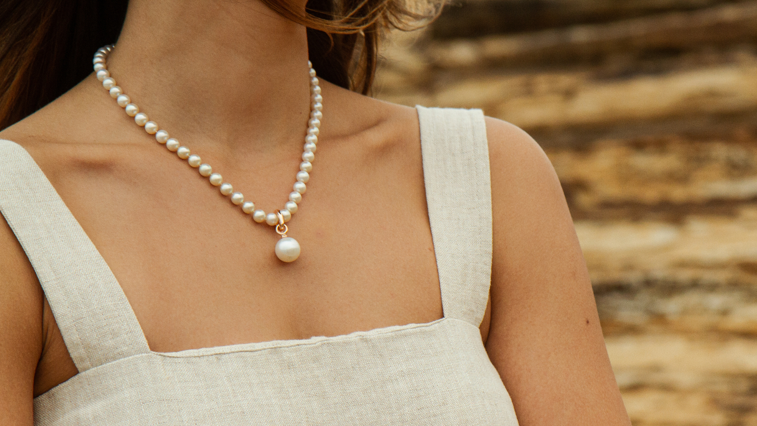 A woman wears her stunning Australian Akoya pearl strand necklace adorned with a Pearl Pendant.