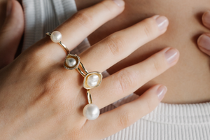 A person wears their assortment of luxury, pearl rings all featuring an Australian saltwater pearl from either Broken Bay or Cygnet Bay Pearl Farms, set in gold and some set alongside beautiful white diamonds.