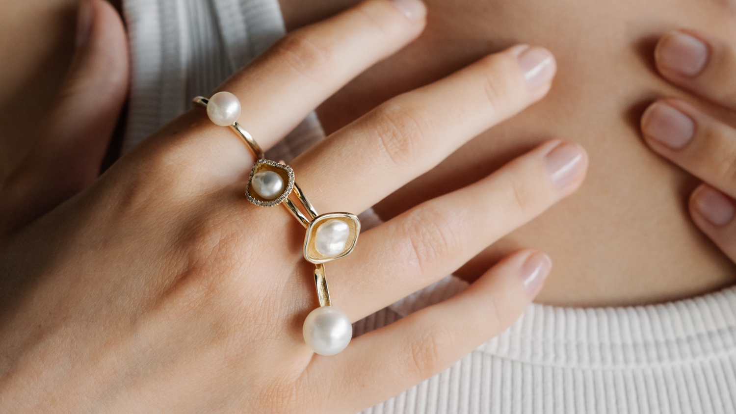 A person wears their assortment of luxury, pearl rings all featuring an Australian saltwater pearl from either Broken Bay or Cygnet Bay Pearl Farms, set in gold and some set alongside beautiful white diamonds.