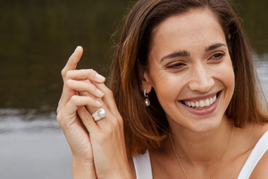 A woman smiles as she wears her beautiful set of Stella collection pieces, all Australian South Sea pearls set alongside white diamonds. 