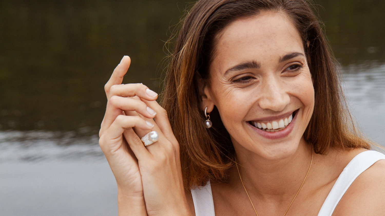 A woman smiles as she wears her beautiful set of Stella collection pieces, all Australian South Sea pearls set alongside white diamonds. 