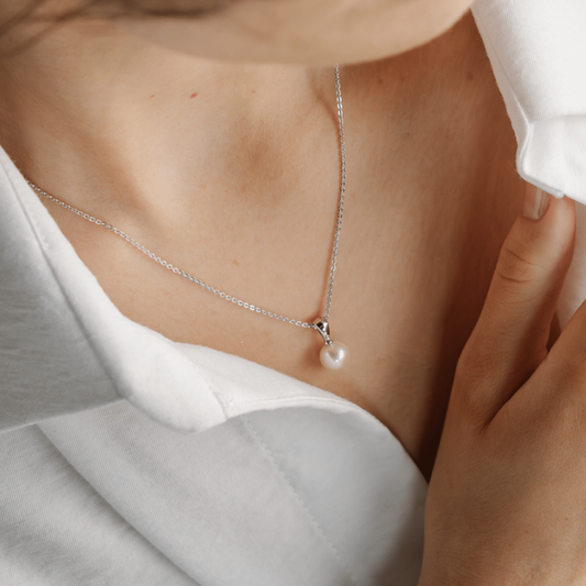 A woman wears her classic Acacia Petite Pearl Pendant featureing an Australian Akoya Broken Bay (NSW) pearl set in sterling silver.