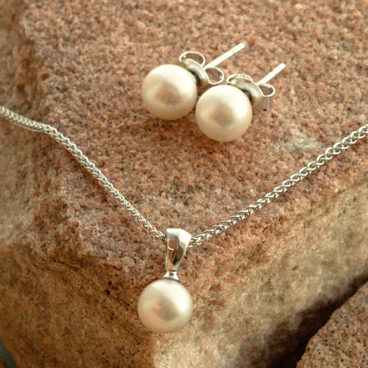 A beautiful Australian Akoya pearl jewellery set that includes a pair of pearl studs with a matching pearl pendant set in sterling silver.