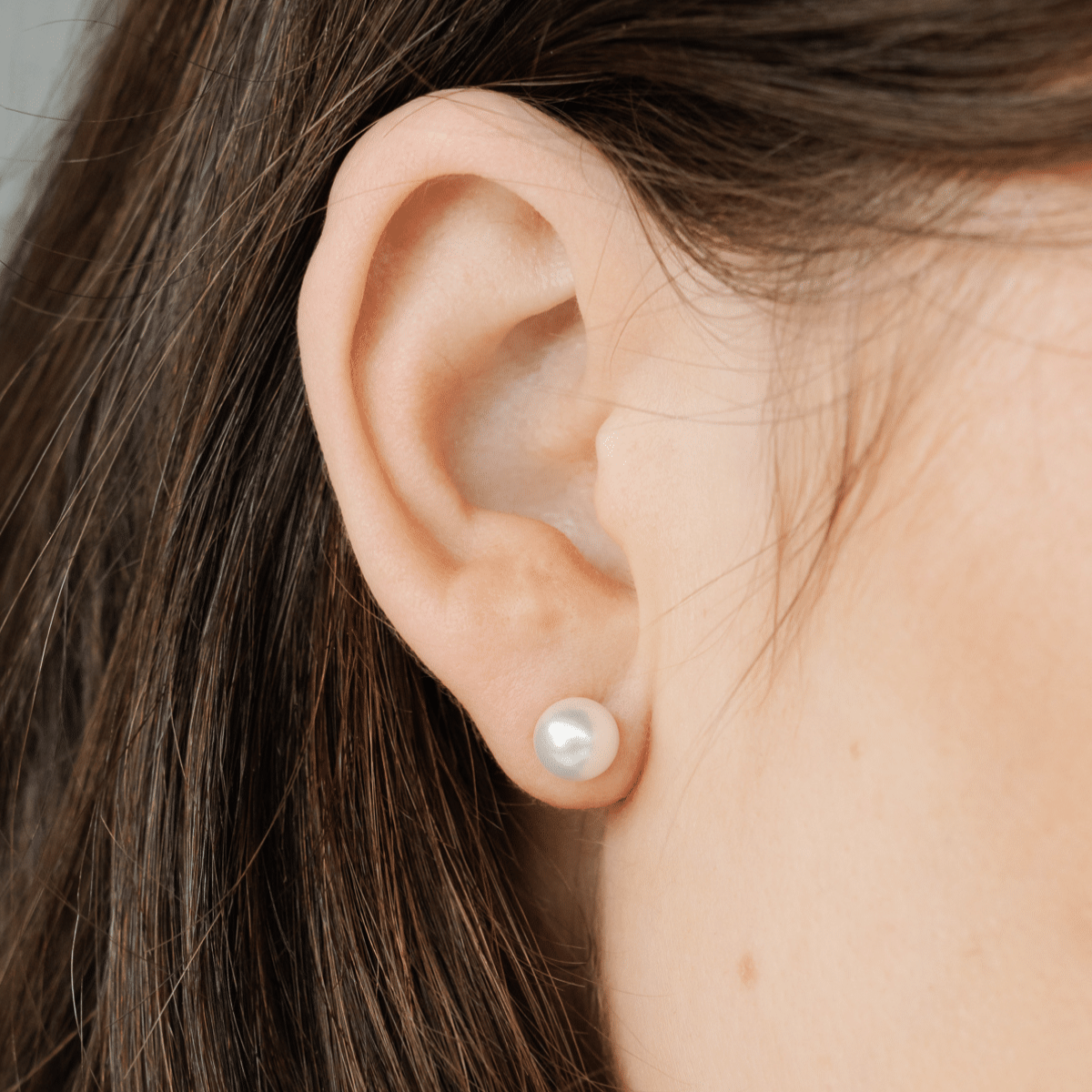 A woman wears her beautiful Australian Akoya pearl studs. 