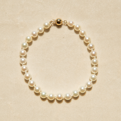 Pearl strand bracelet on a beige background
