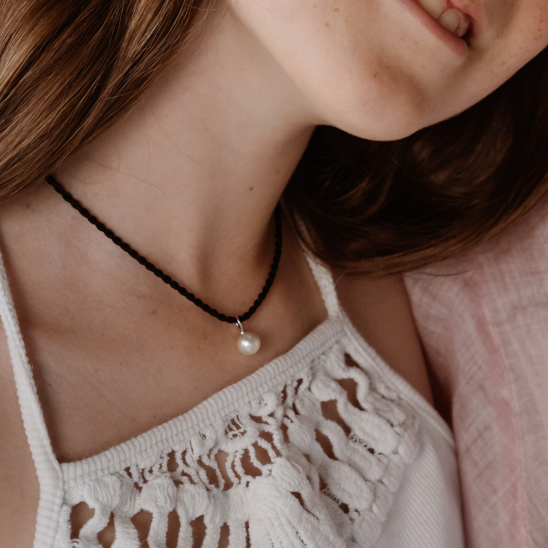 A girl wears her stunning Australian Akoya charm pendant on a Black Silk Cord Rope.