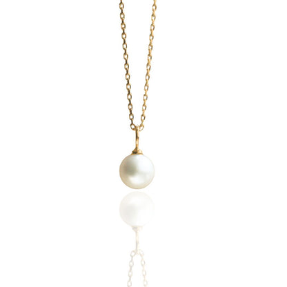 An Australian Akoya pearl set on a yellow gold charm pendant. 