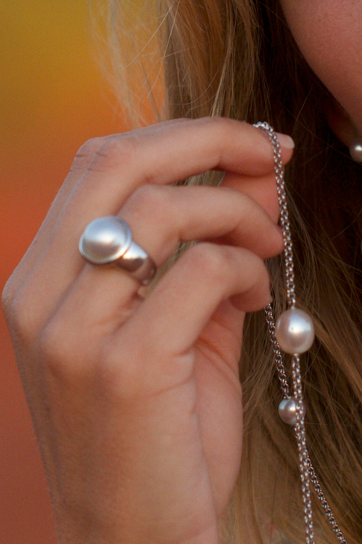 A photo of a person wearing their beautiful Mabe pearl ring set in sterling silver.