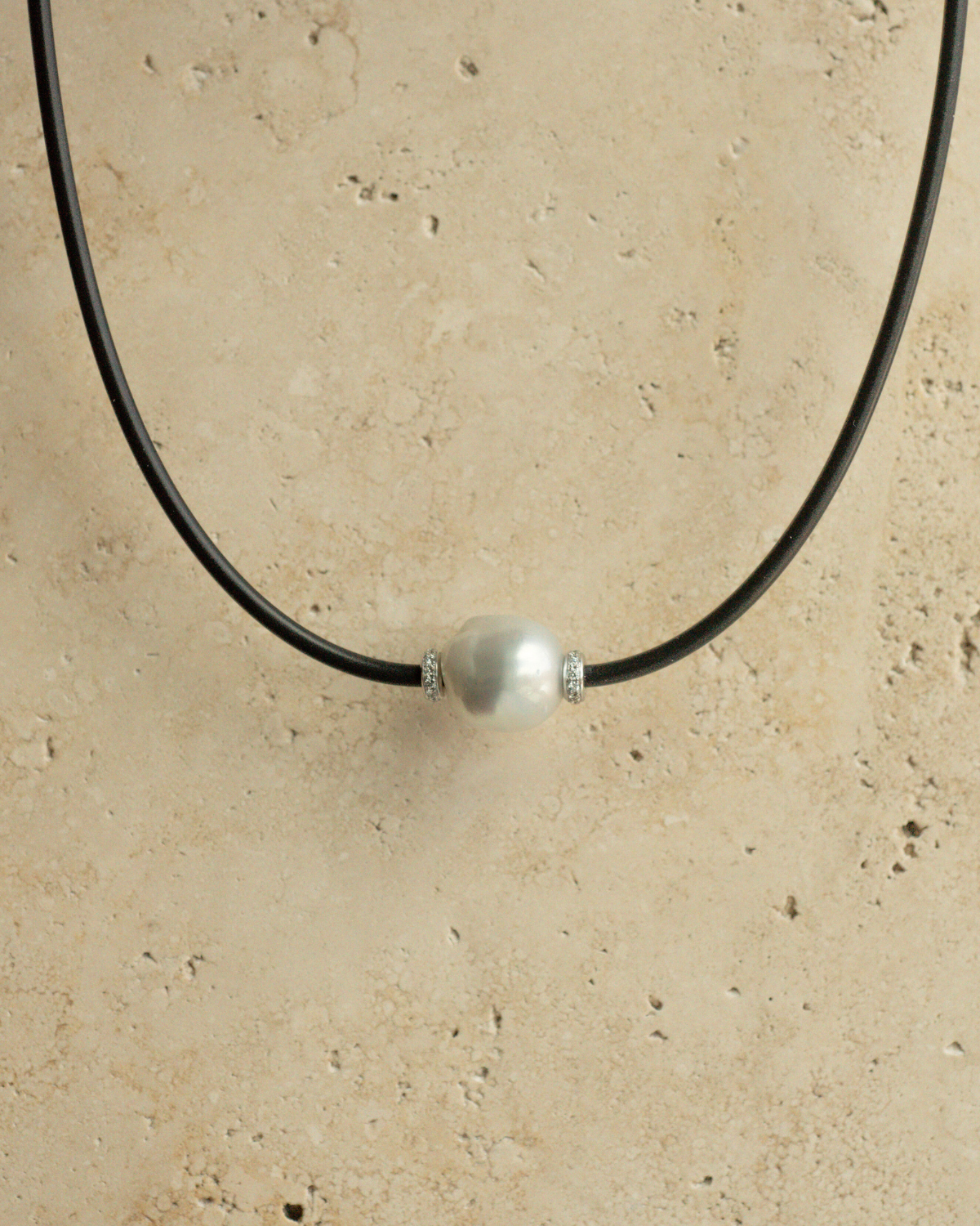 A gorgeous Baroque Australian South Sea pearl set alongside two white diamond rondels on a neoprene necklace.